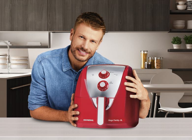 homem segurando air fryer
